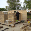 photograph on site at pear tree farm with the bricklayer putting up the internal blockwork walls